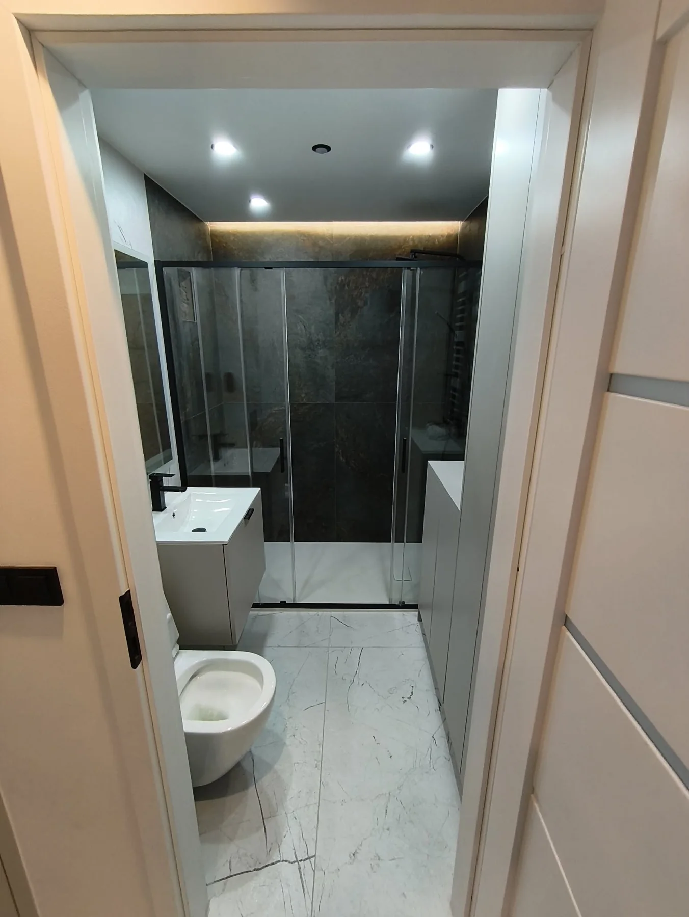 Badezimmer nach der Renovierung mit Fliesen und Duschwanne